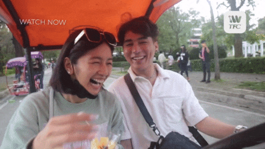 Kaori and JC laughing together on a bicycle